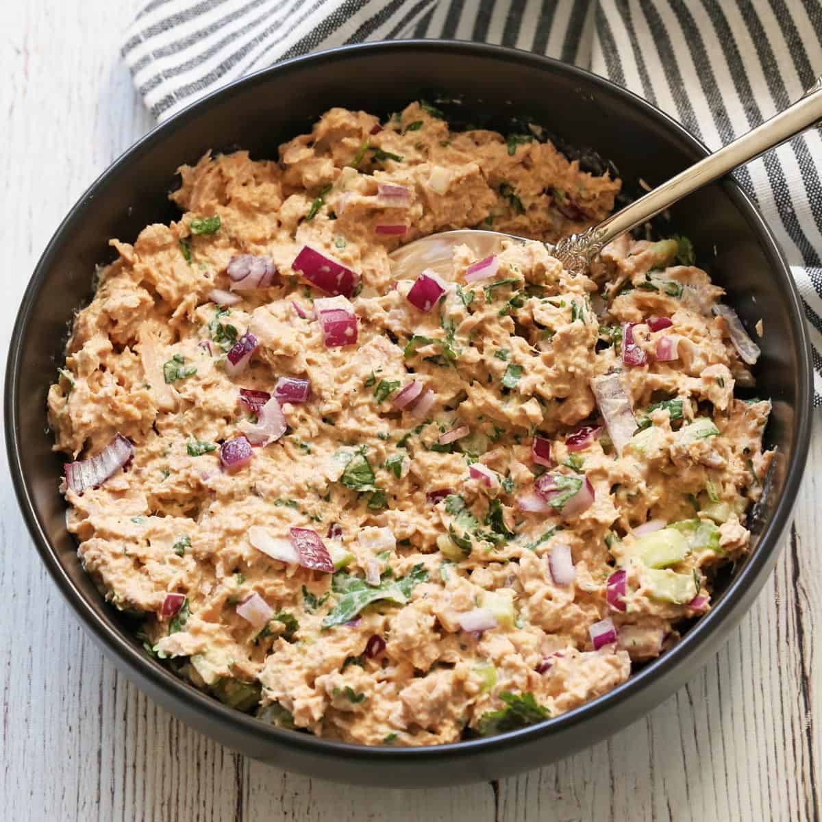 Tuna salad is served in a bowl with a spoon.