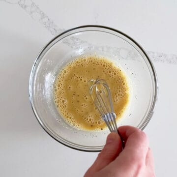 Mixing in the back pepper, garlic, and Dijon mustard.