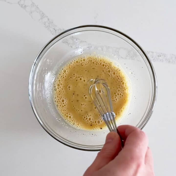 Mixing in the back pepper, garlic, and Dijon mustard.