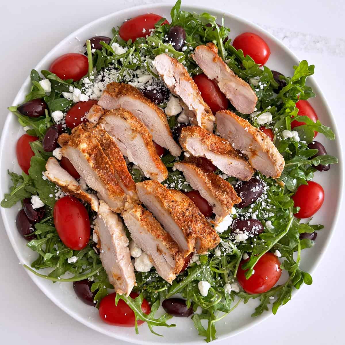 A salad with slices of leftover chicken thighs.