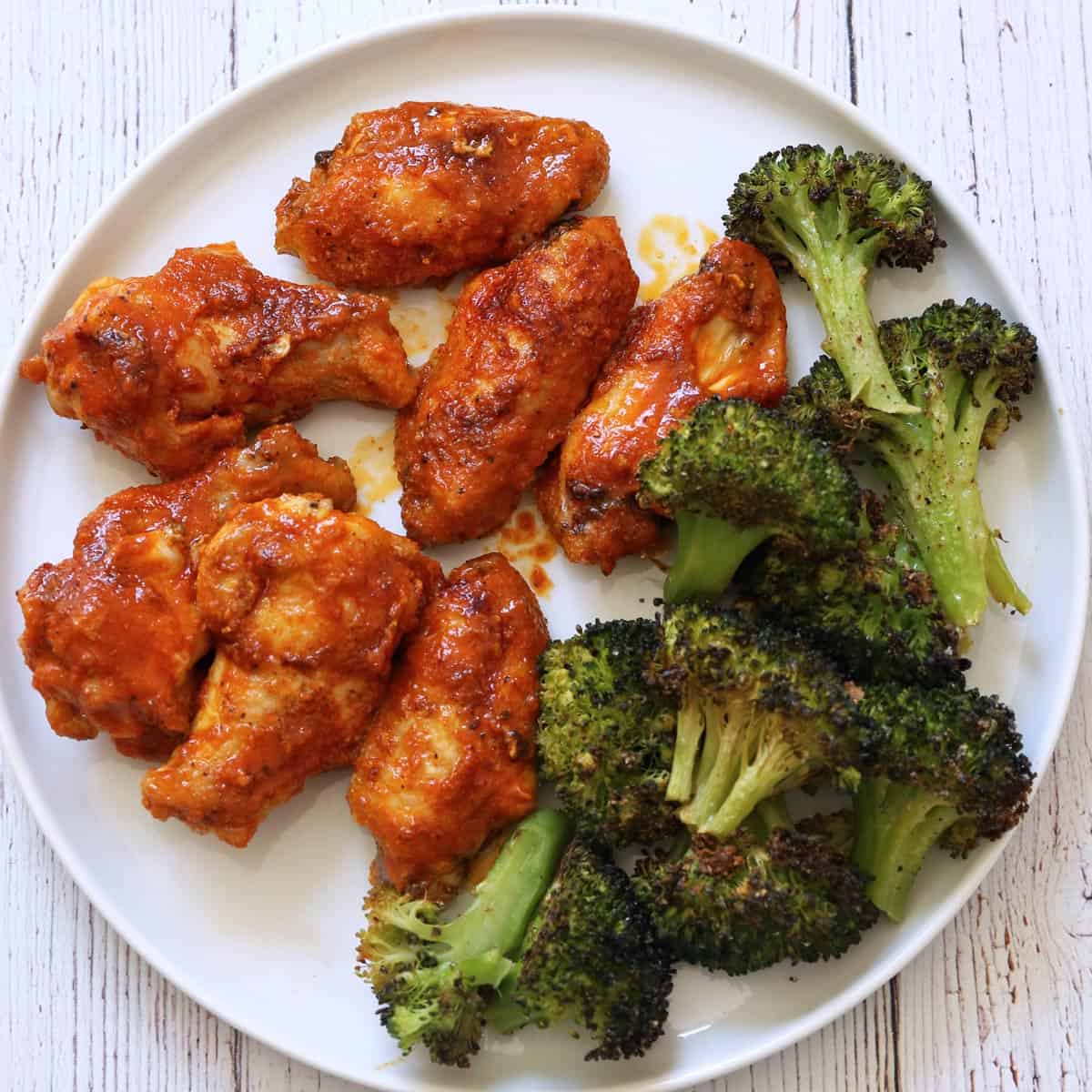 Buffalo wings are served with broccoli.