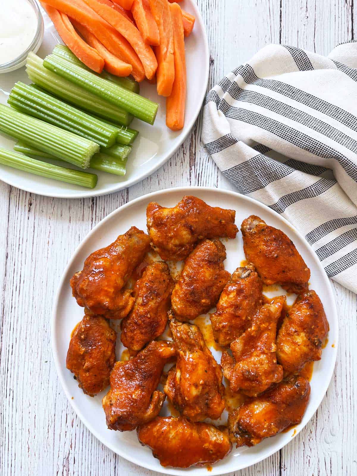 Buffalo wings are served with veggies and a dip.