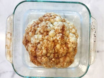 The cauliflower is in the pan and ready to be baked.
