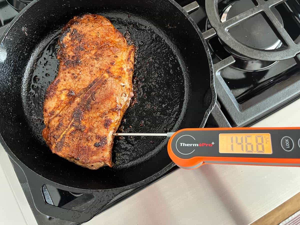 Checking the steak's internal temperature with a thermometer.