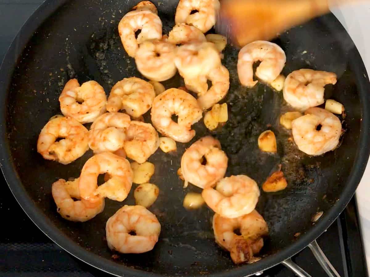 Cooking shrimp and garlic in a skillet.