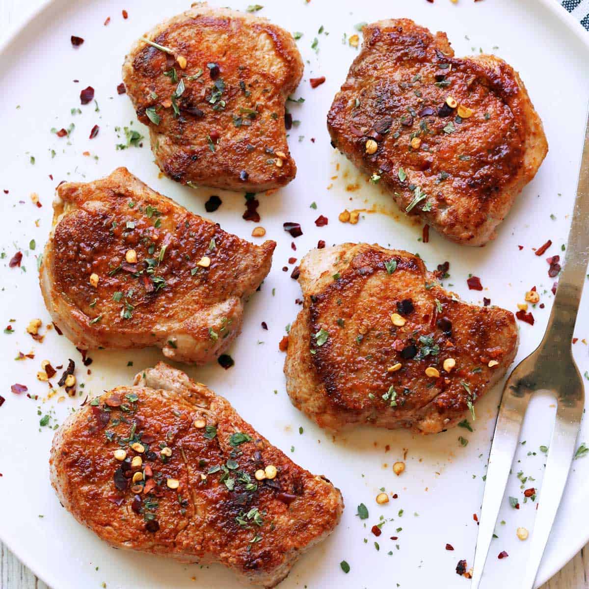 Pork medallions are served on a white plate.