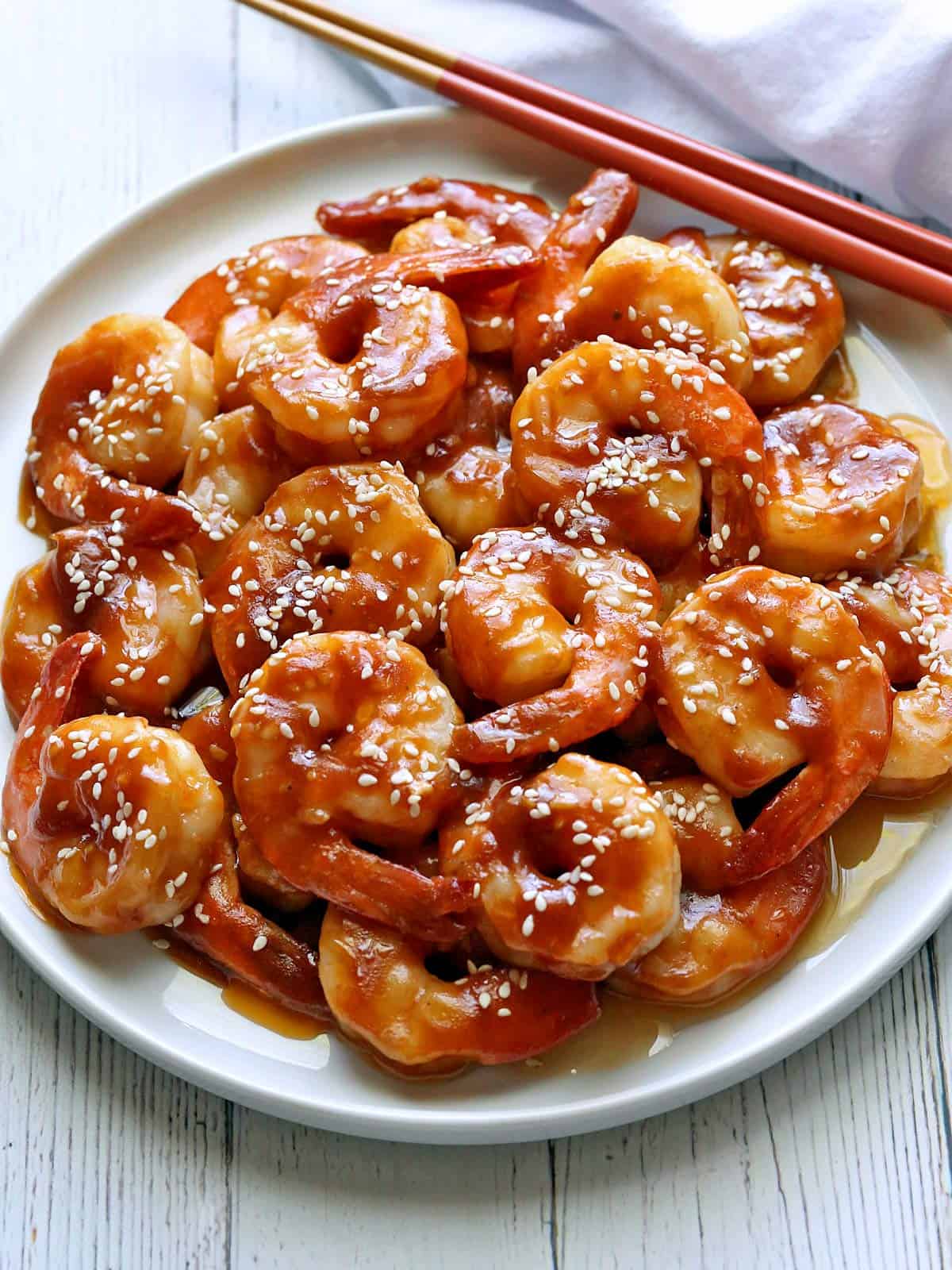 Sesame shrimp are served with chopsticks.