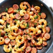 Shrimp and sausage are served in a skillet.