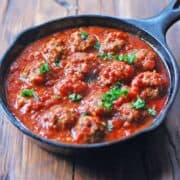 Spicy meatballs are served in a cast-iron skillet.