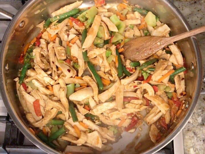 The stir fry is ready in the skillet.