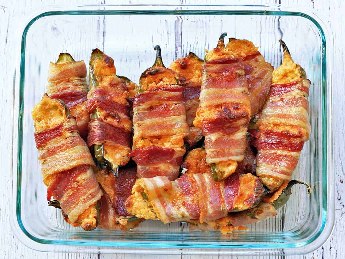 Stuffed jalapenos are stored in a food storage container.