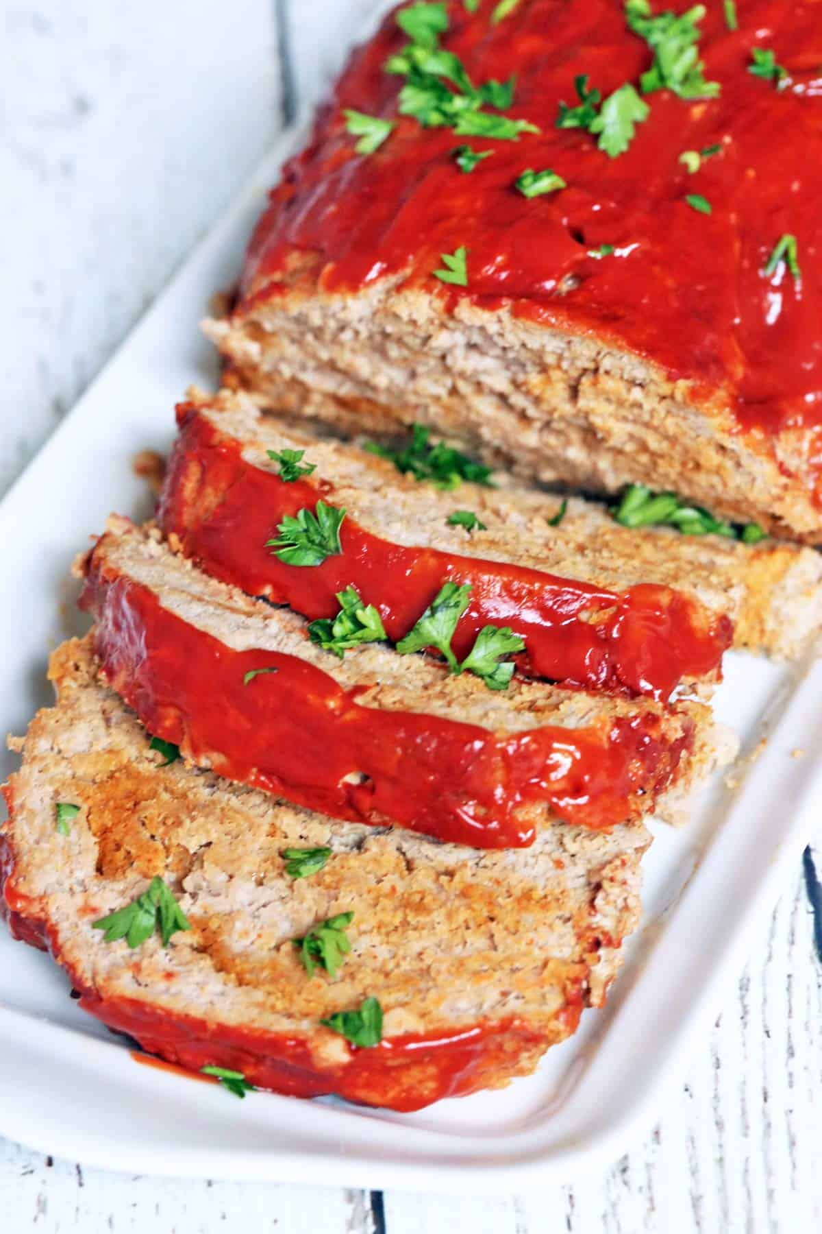 A sliced turkey meatloaf is served on a white tray.
