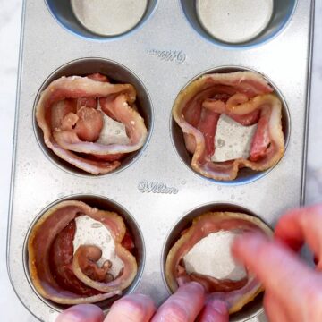 Adding par cooked bacon strips to the muffin pan cavities.