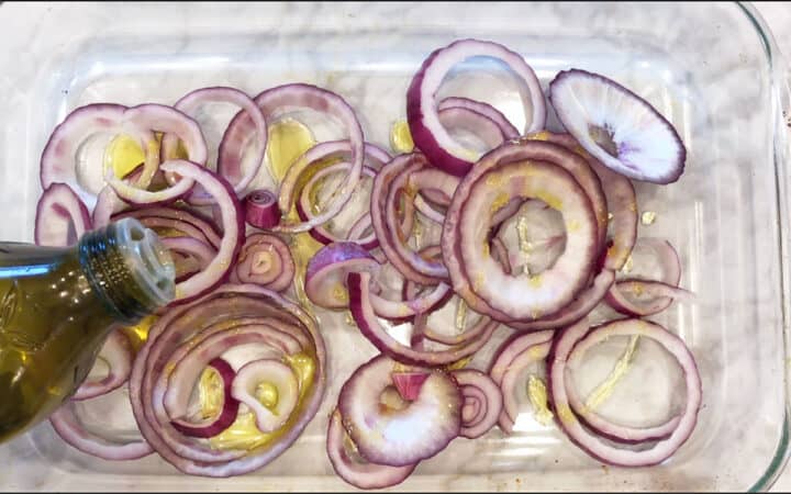 Adding olive oil to the onions.