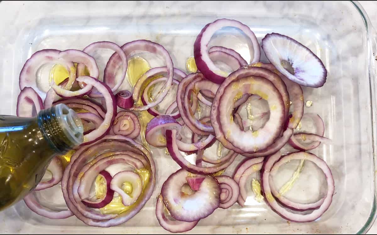 Adding olive oil to the onions.