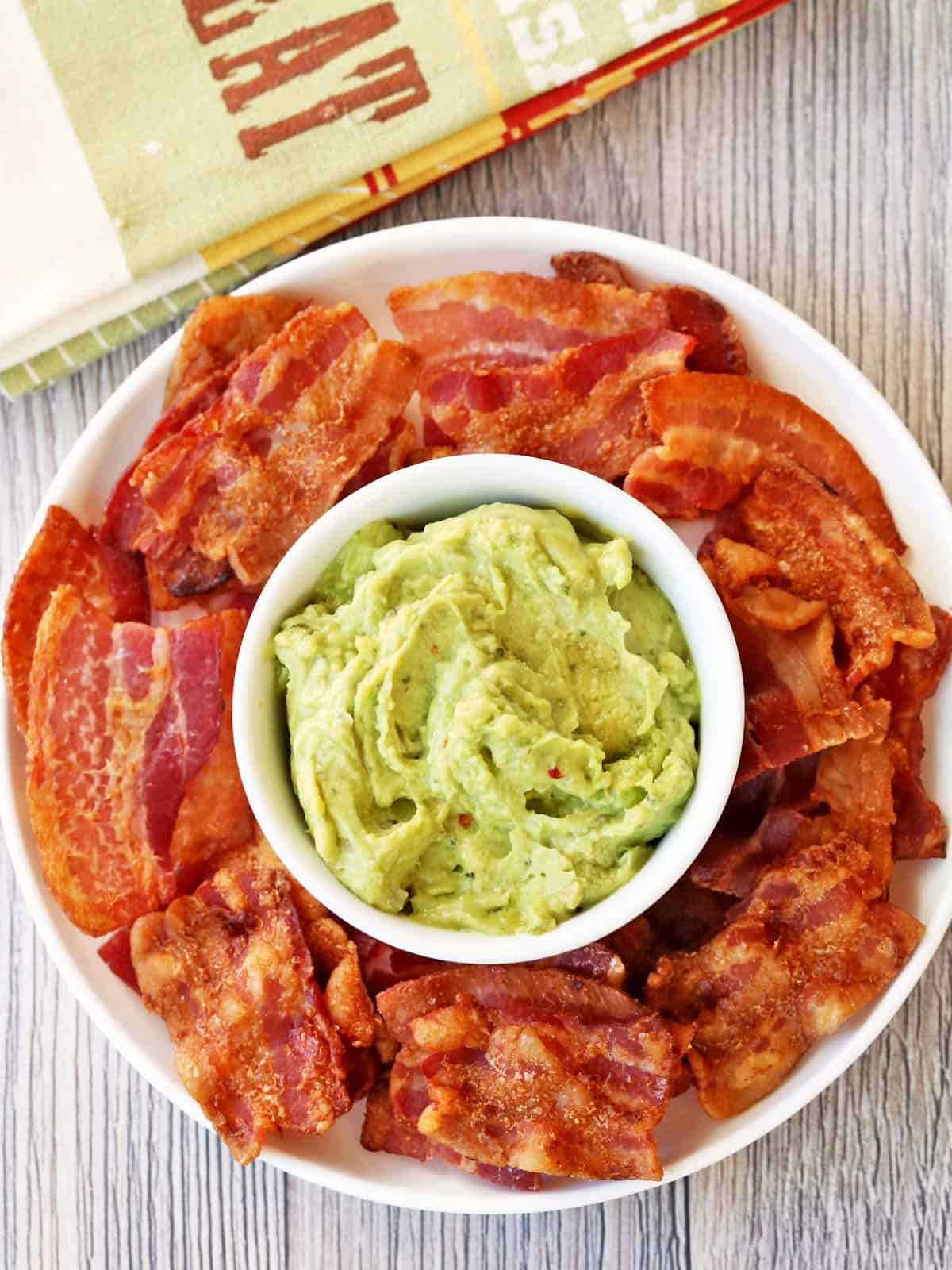 Bacon chips are served with guacamole.