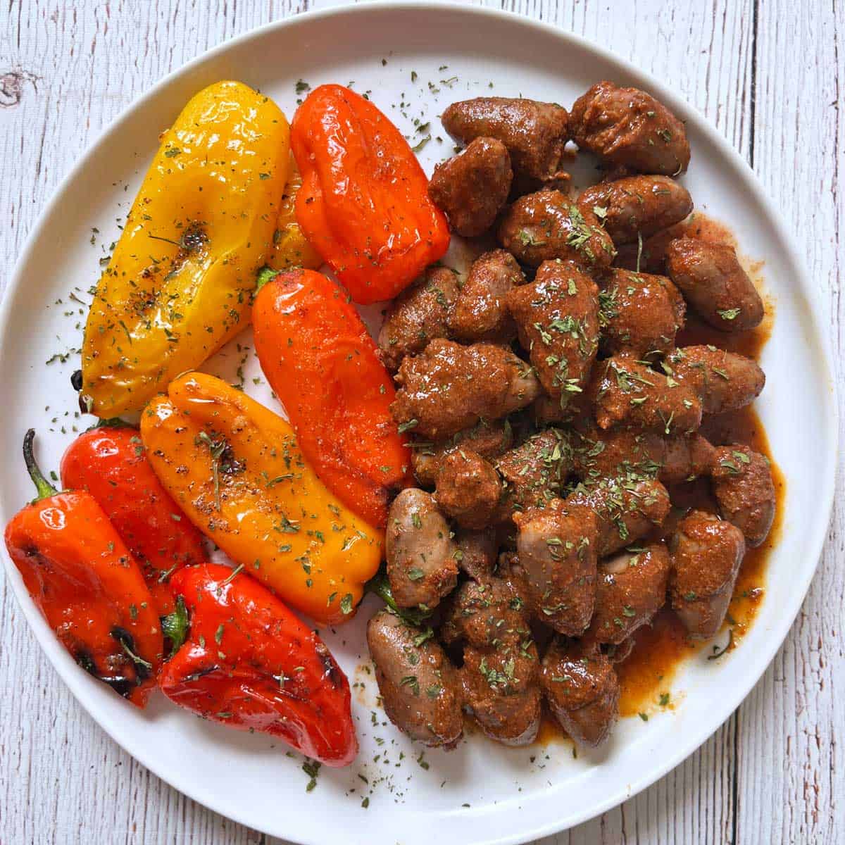 Chicken hearts are served with mini peppers.