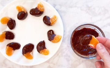 Dipping the orange segments in melted chocolate.