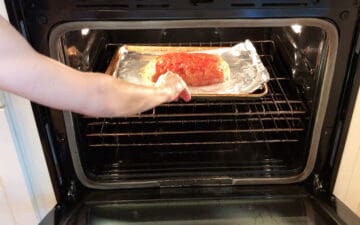 Placing the meatloaf in the oven.
