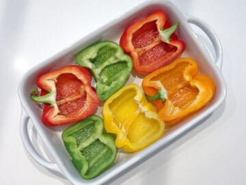 Halved bell peppers in a baking dish.