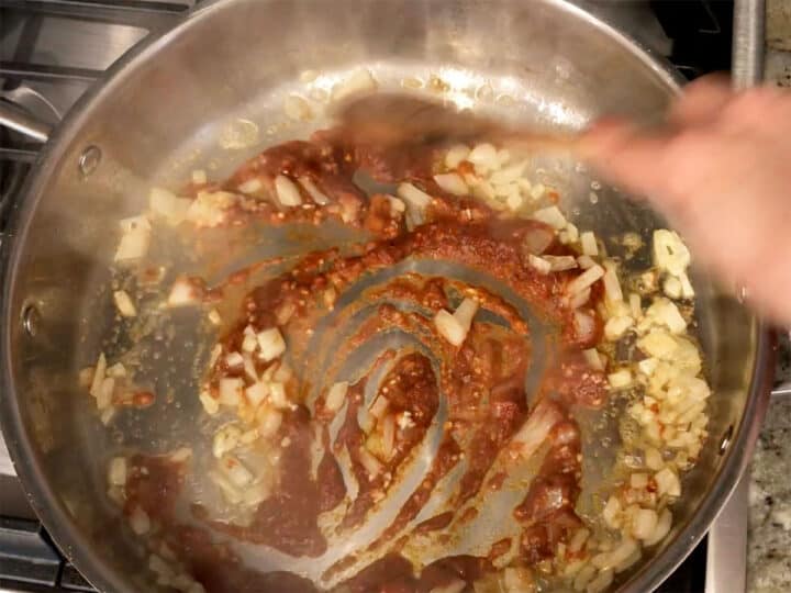 Adding the seasoning paste to the skillet.