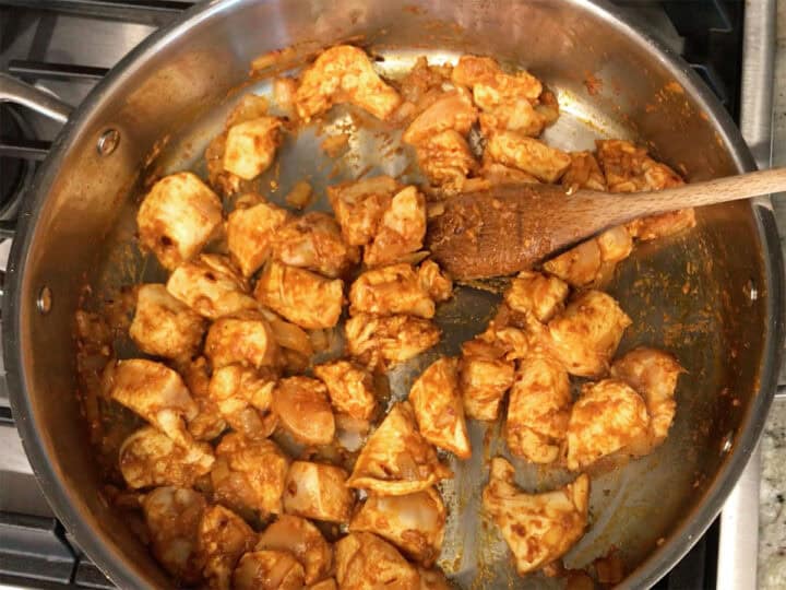 Coating the chicken in the seasoning paste.