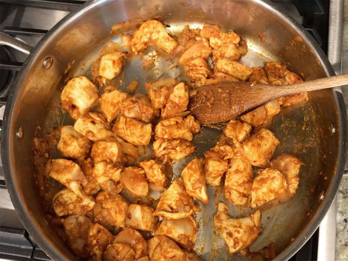 Coating the chicken in the seasoning paste.