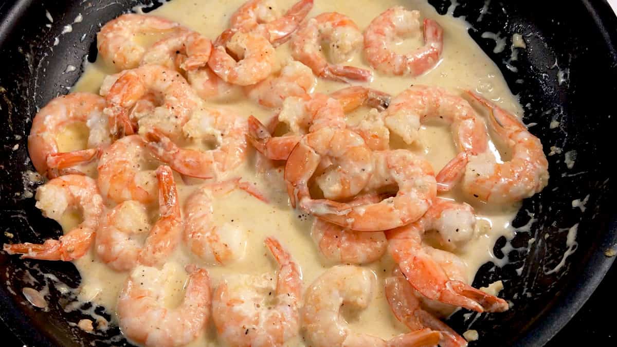 Cooking the shrimp in the sauce.