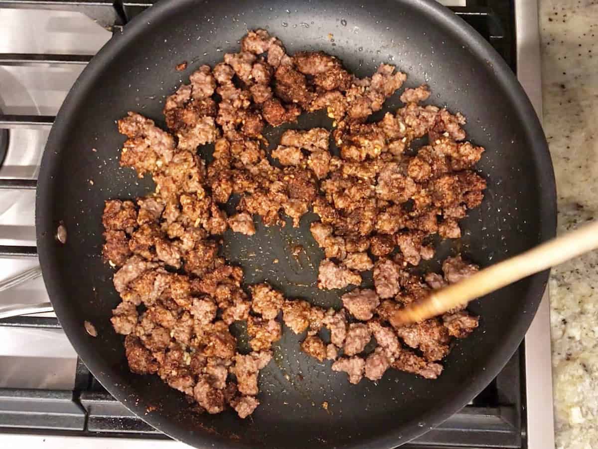 Adding garlic and spices to the ground beef.