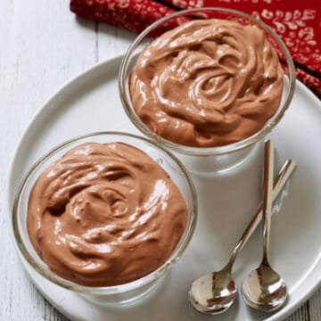 Cottage cheese chocolate mousse is served in dessert glasses with dessert spoons.