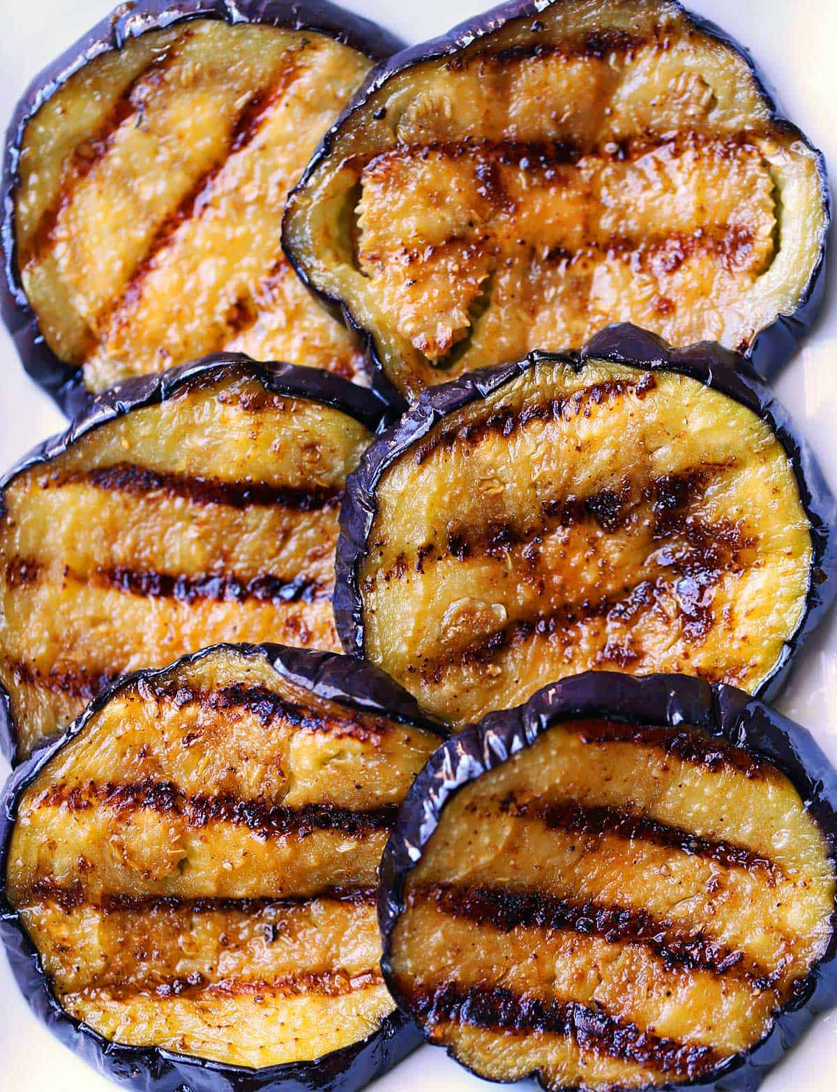 Six slices of grilled eggplant.