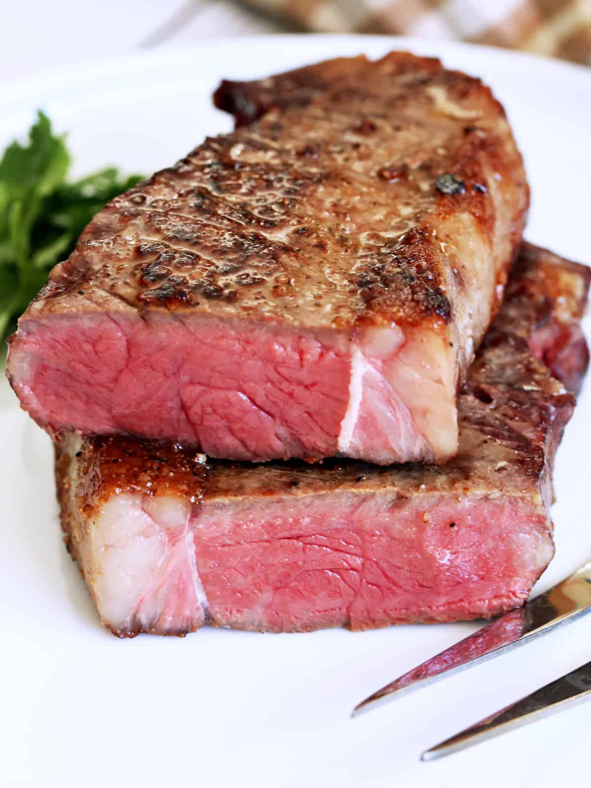 Reverse seared steak was cut in half to show its medium-rare inside.