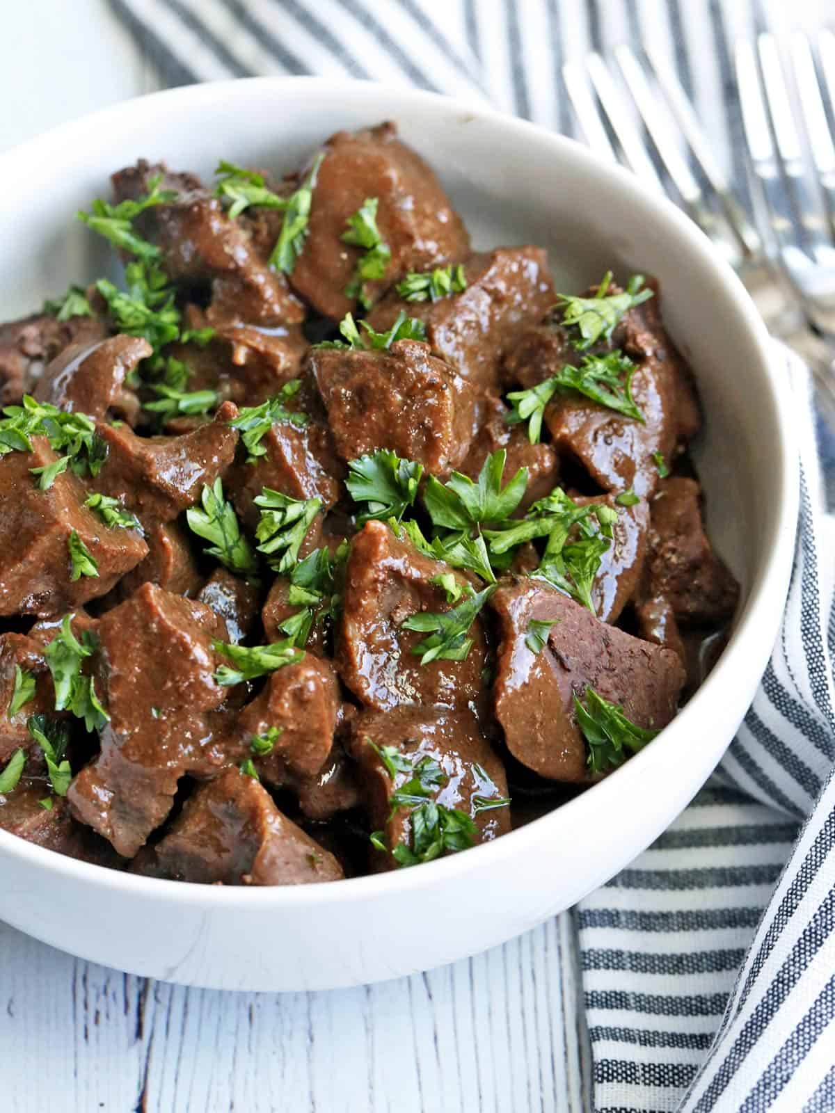 Beef heart is served in a white bowl.