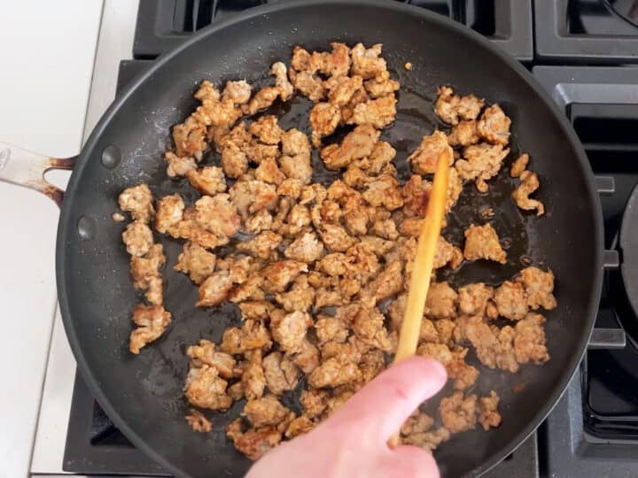 Cooking sausage in a skillet.