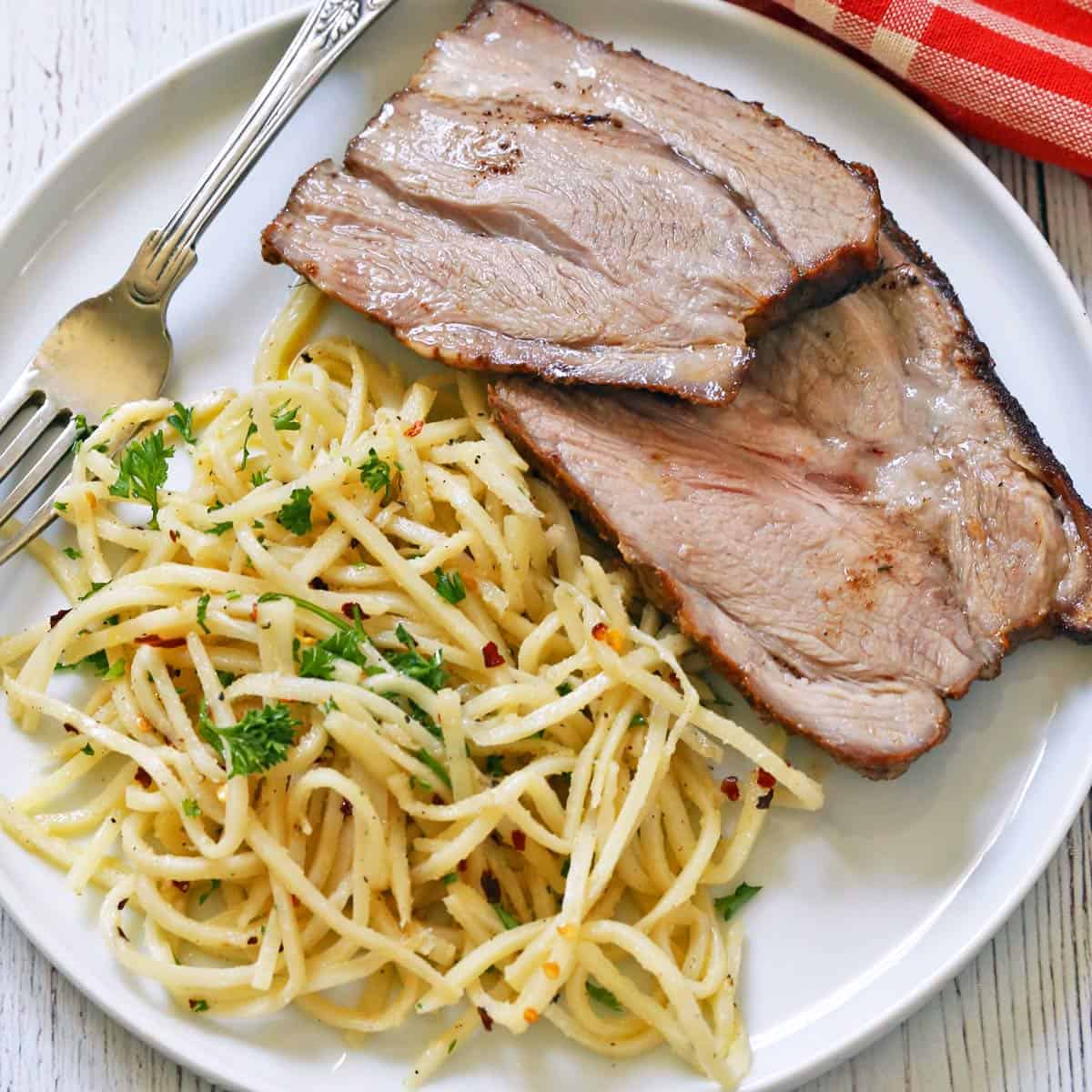Hearts of palm pasta is served as a side dish to sliced pork roast.
