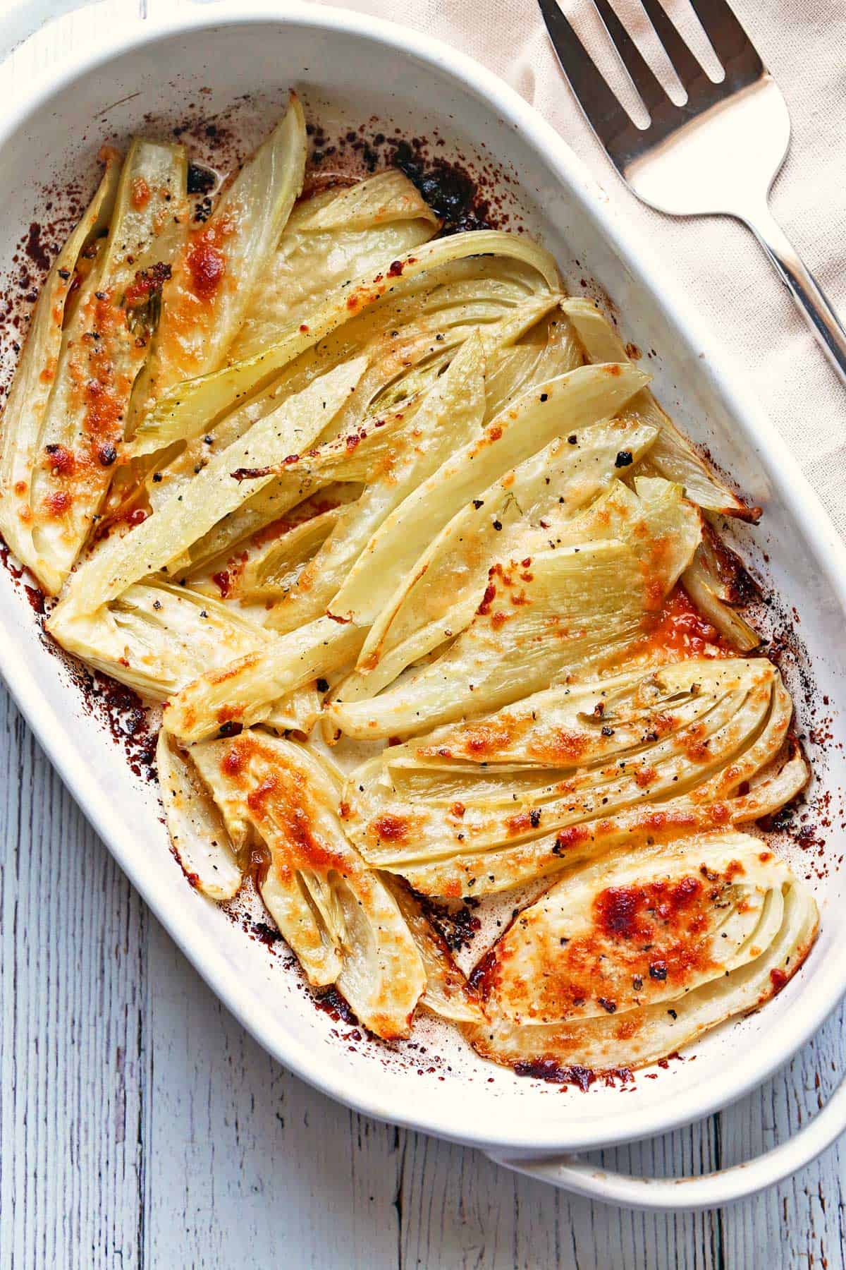Roasted fennel is served in a white baking dish.