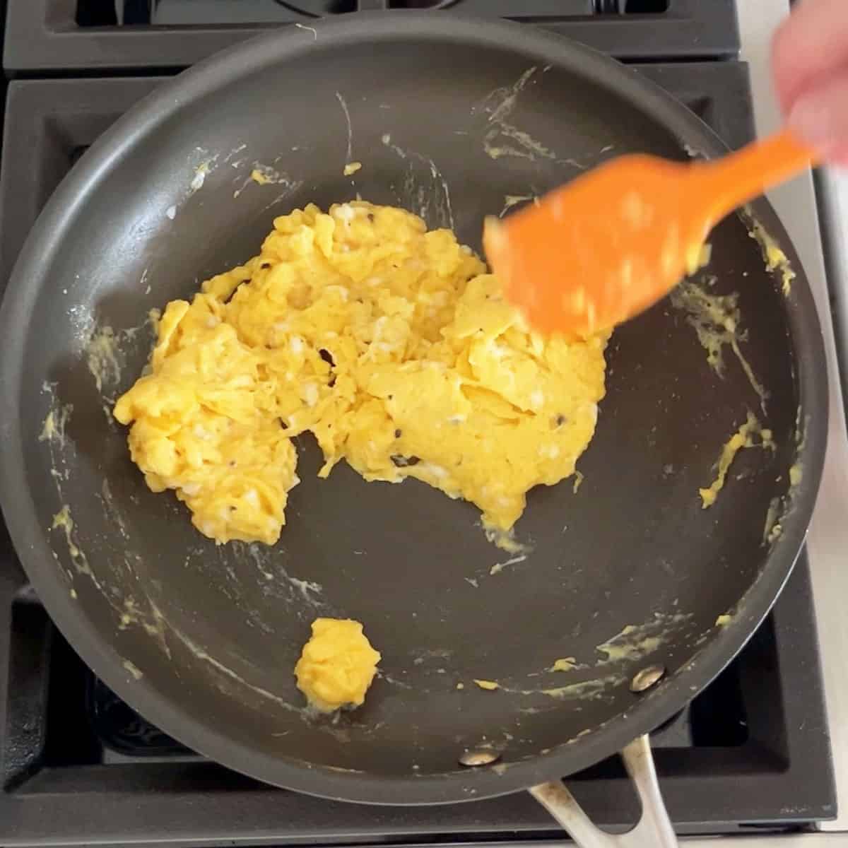 Scrambling the eggs in a skillet.