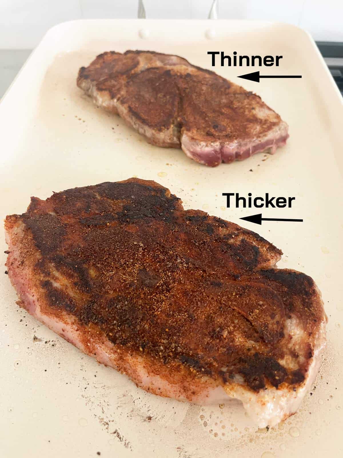 Two pork steaks, one thicker, one thinner.