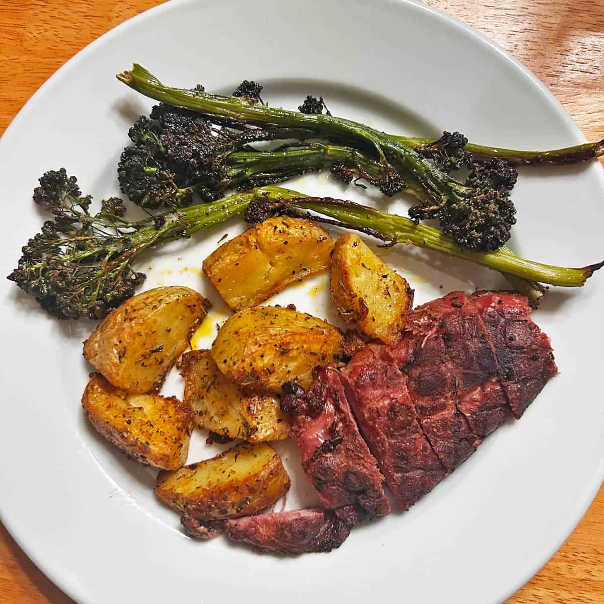 Roasted broccolini is served with duck breast and potatoes.