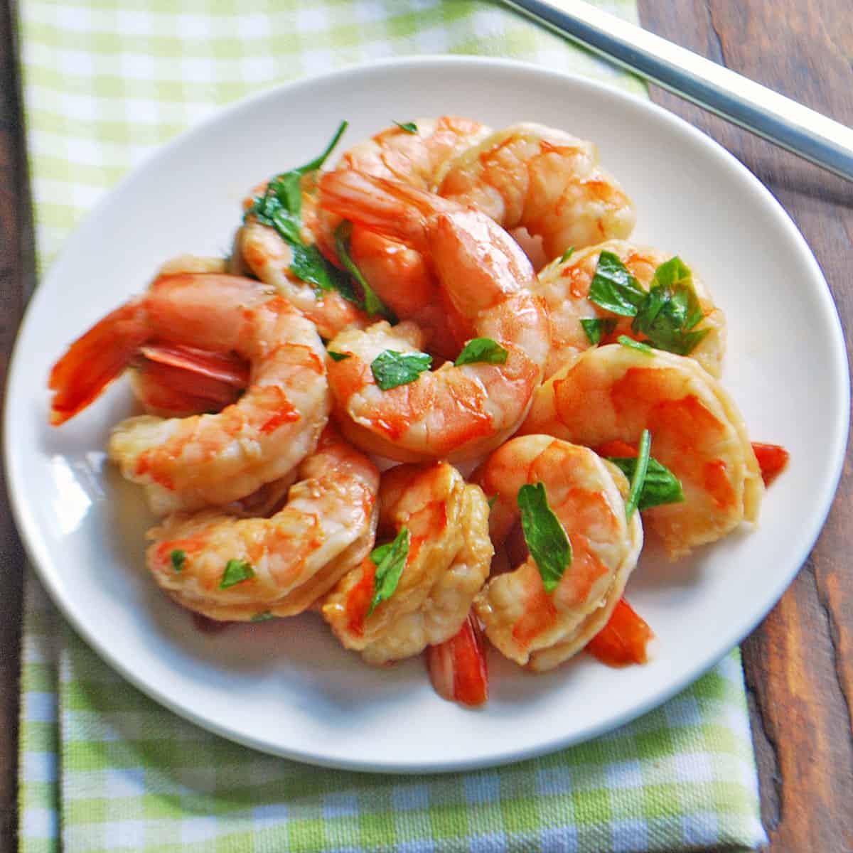 Asian-style shrimp salad is served on a white plate.