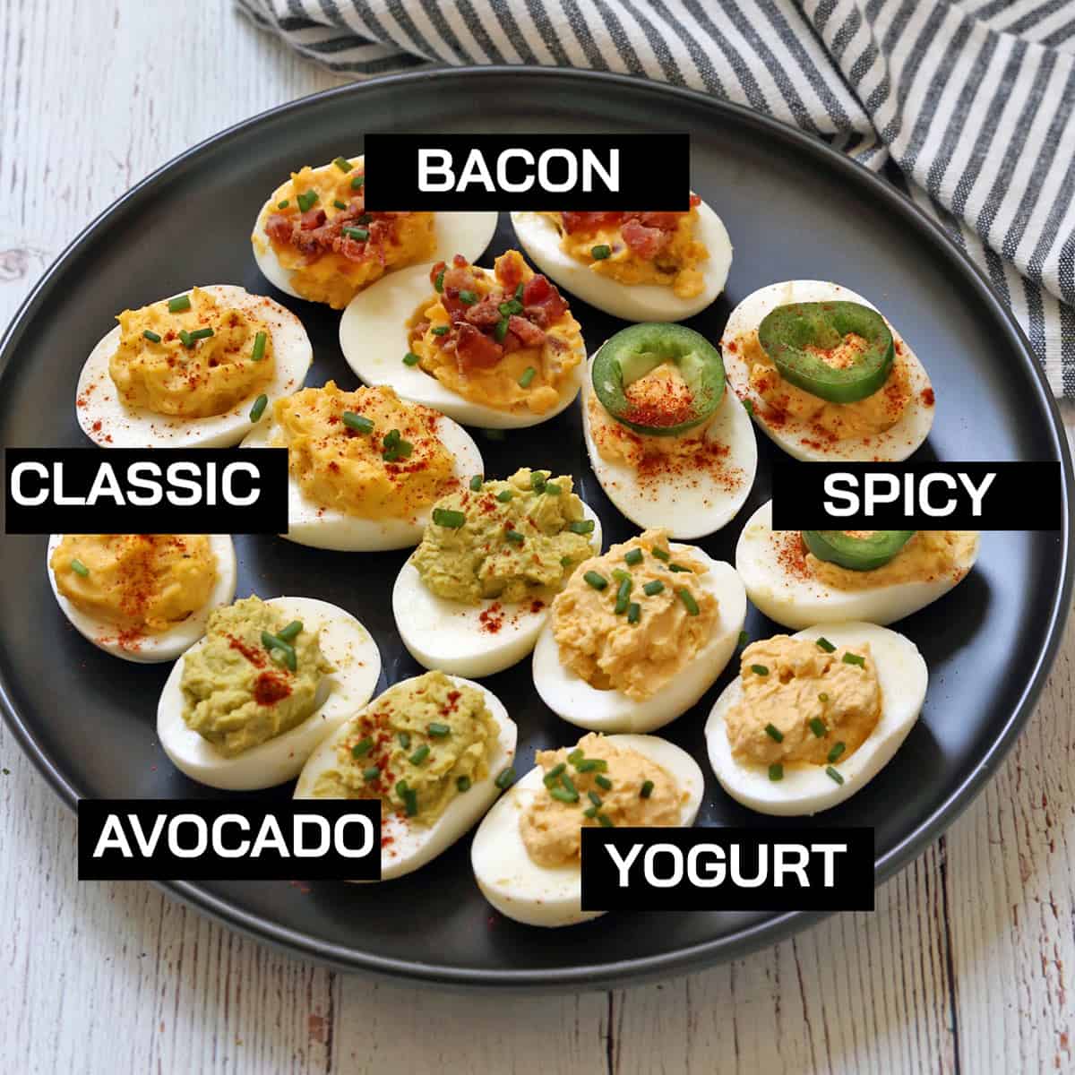 Five variations of deviled eggs on a plate.