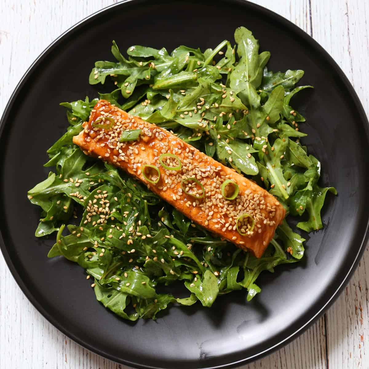Leftover Asian salmon is served on a bed of arugula.