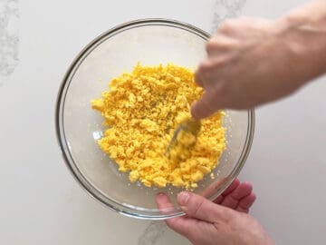 Mashing the egg yolks.