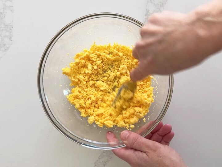 Mashing the egg yolks.
