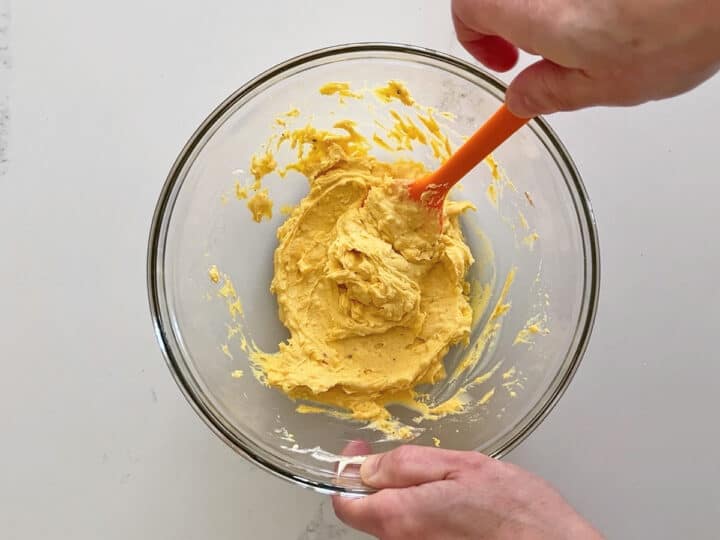 Mixing the yolks with the condiments.