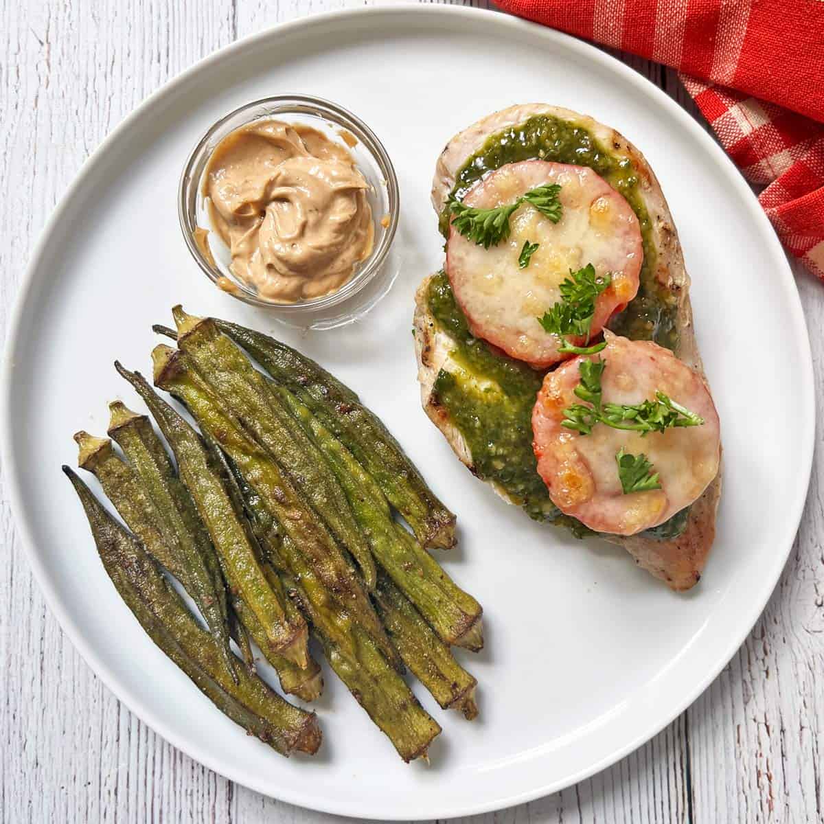 Pesto chicken is served with roasted okra.