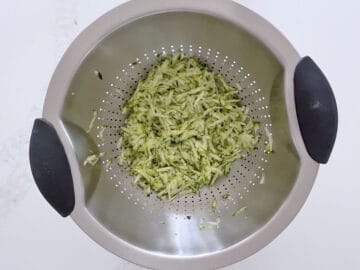 Straining the grated zucchini.