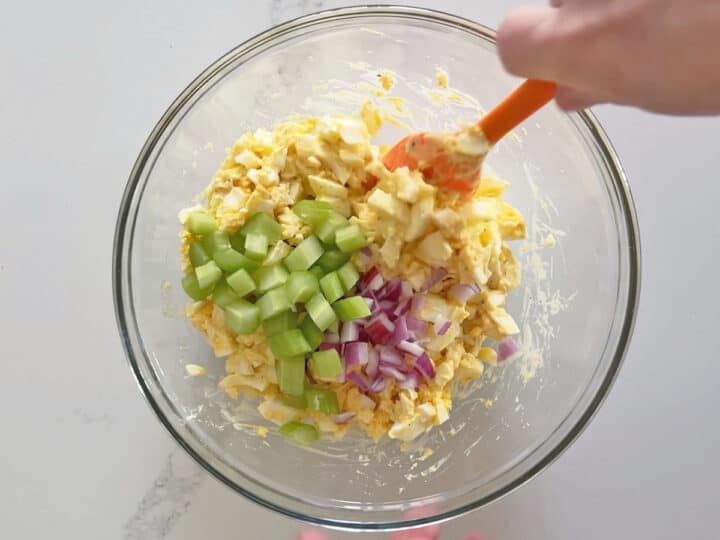 Adding celery and onions to the salad.