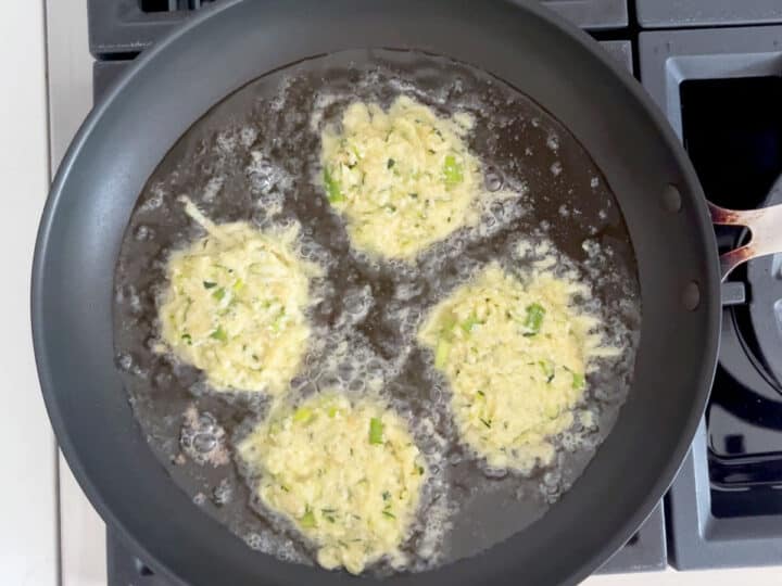 Four mounds of the zucchini mixture were added to the skillet.