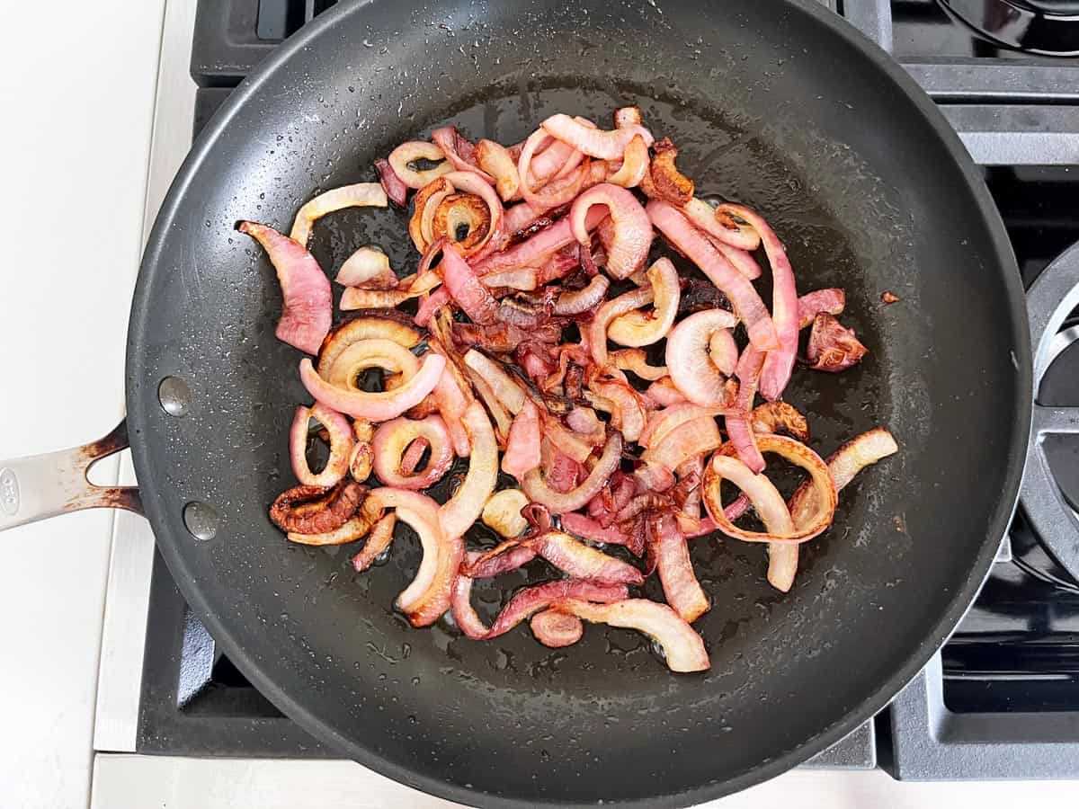 Cooked red onions in a skillet.
